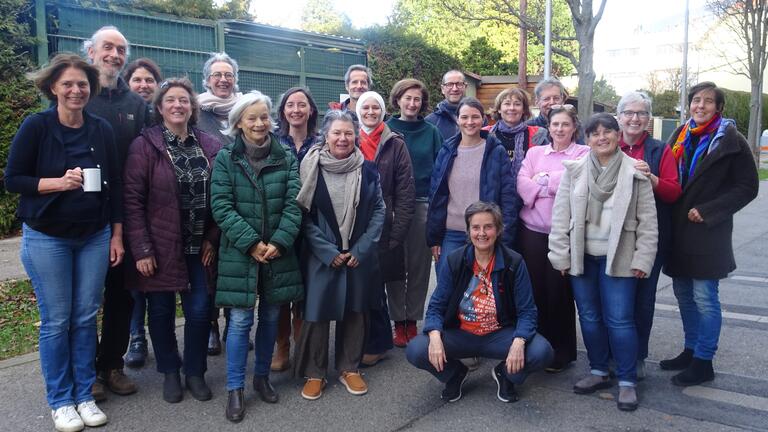 Auf dem Foto stehen die Teilnehmenden mit der Referentin in einem Außenbereich zusammen und lächeln.